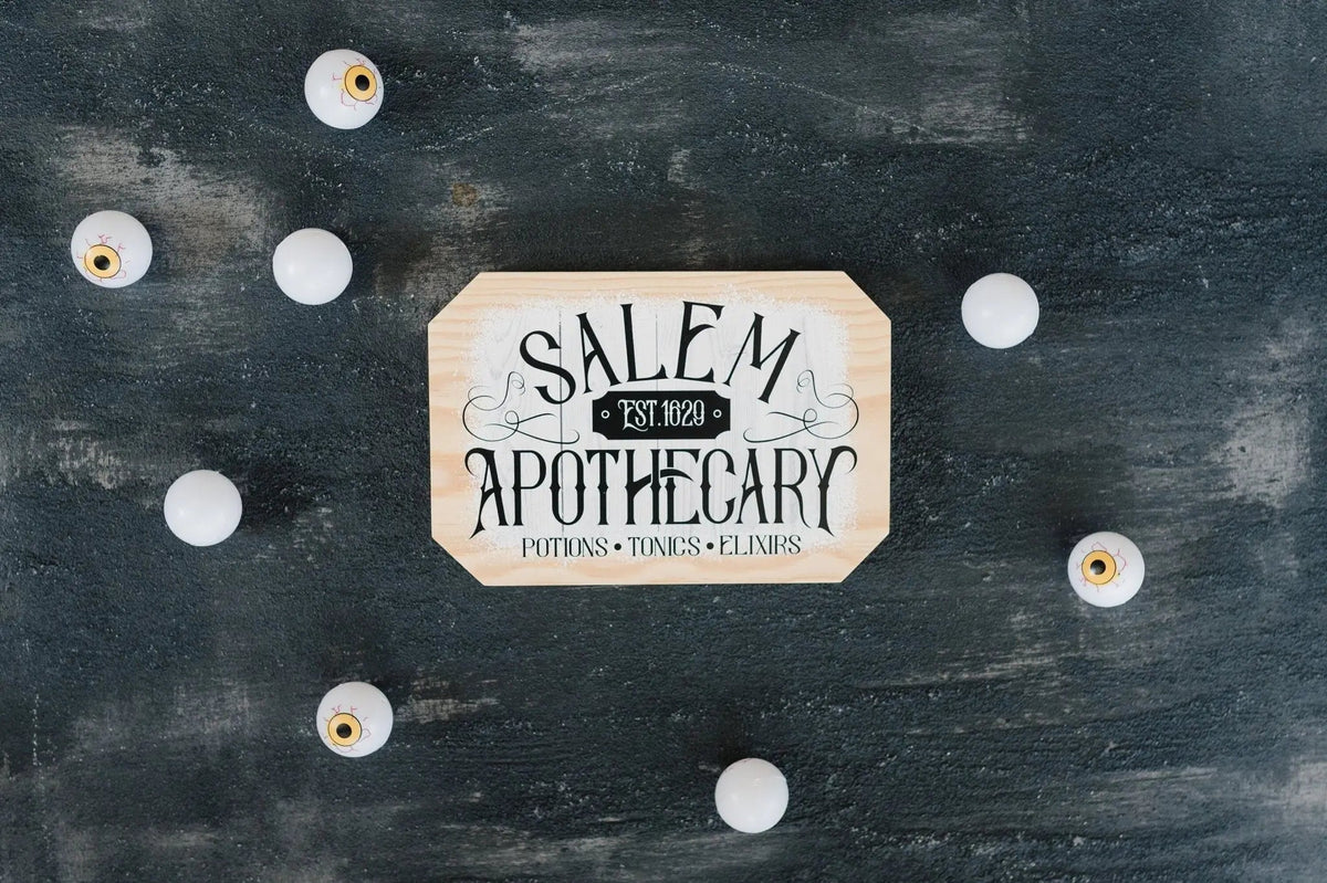 Octagonal wood block sign with 'SALEM APOTHECARY' lettering and decorative border