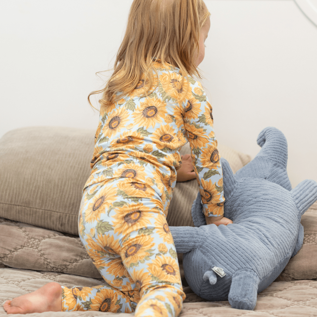 Kids pajama set on child: long-sleeve yellow sunflower print top and matching pants
