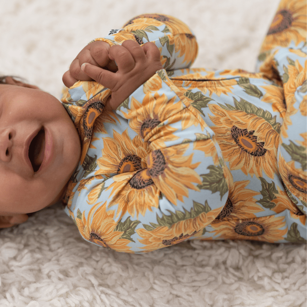 Sunflower-print footed romper with long sleeves and front opening