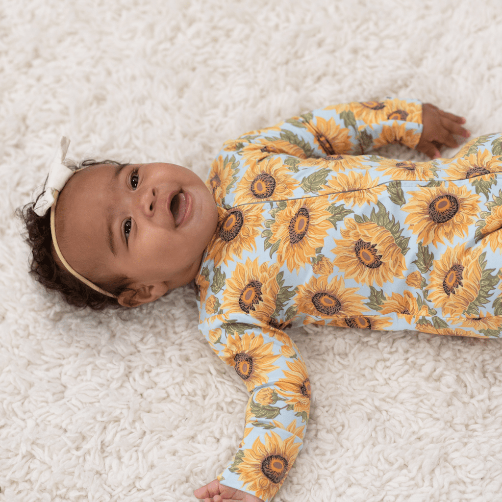 Light blue sunflower-print long-sleeve footed romper with front buttons