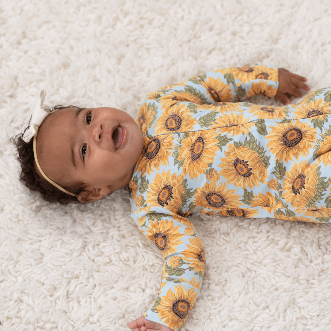 Light blue sunflower-print long-sleeve footed romper with front buttons