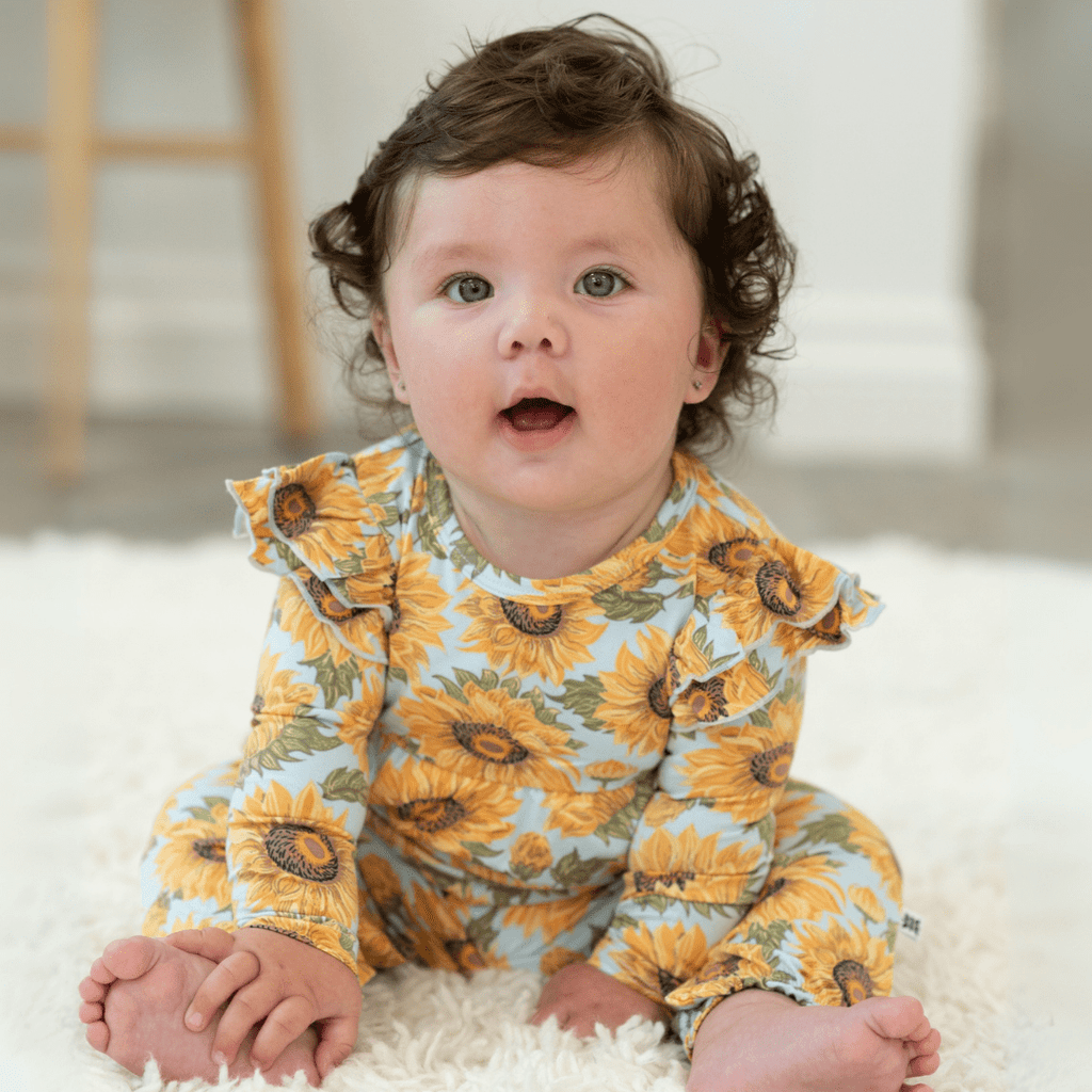 Sunflower print flutter-sleeve romper in light blue with orange-yellow flower pattern