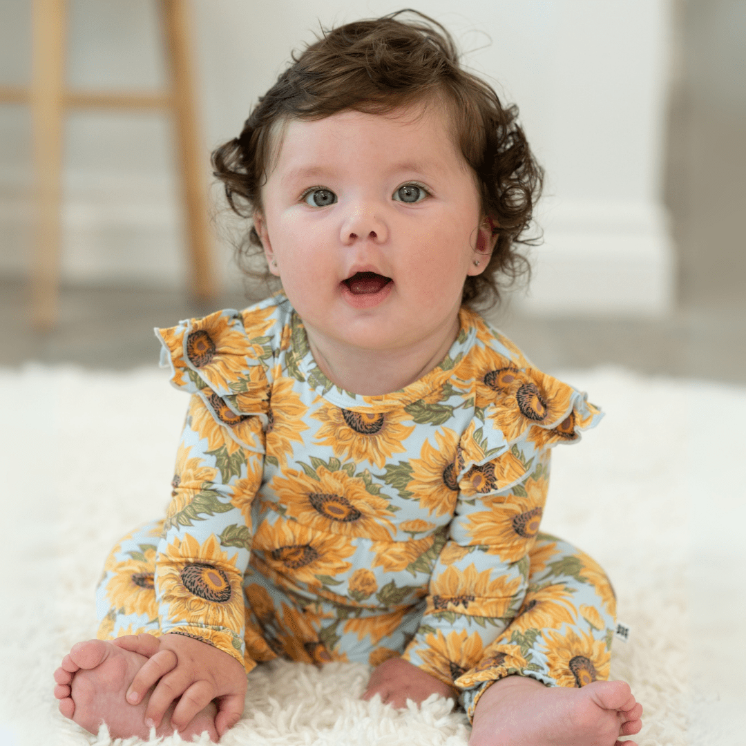 Sunflower print flutter-sleeve romper in light blue with orange-yellow flower pattern