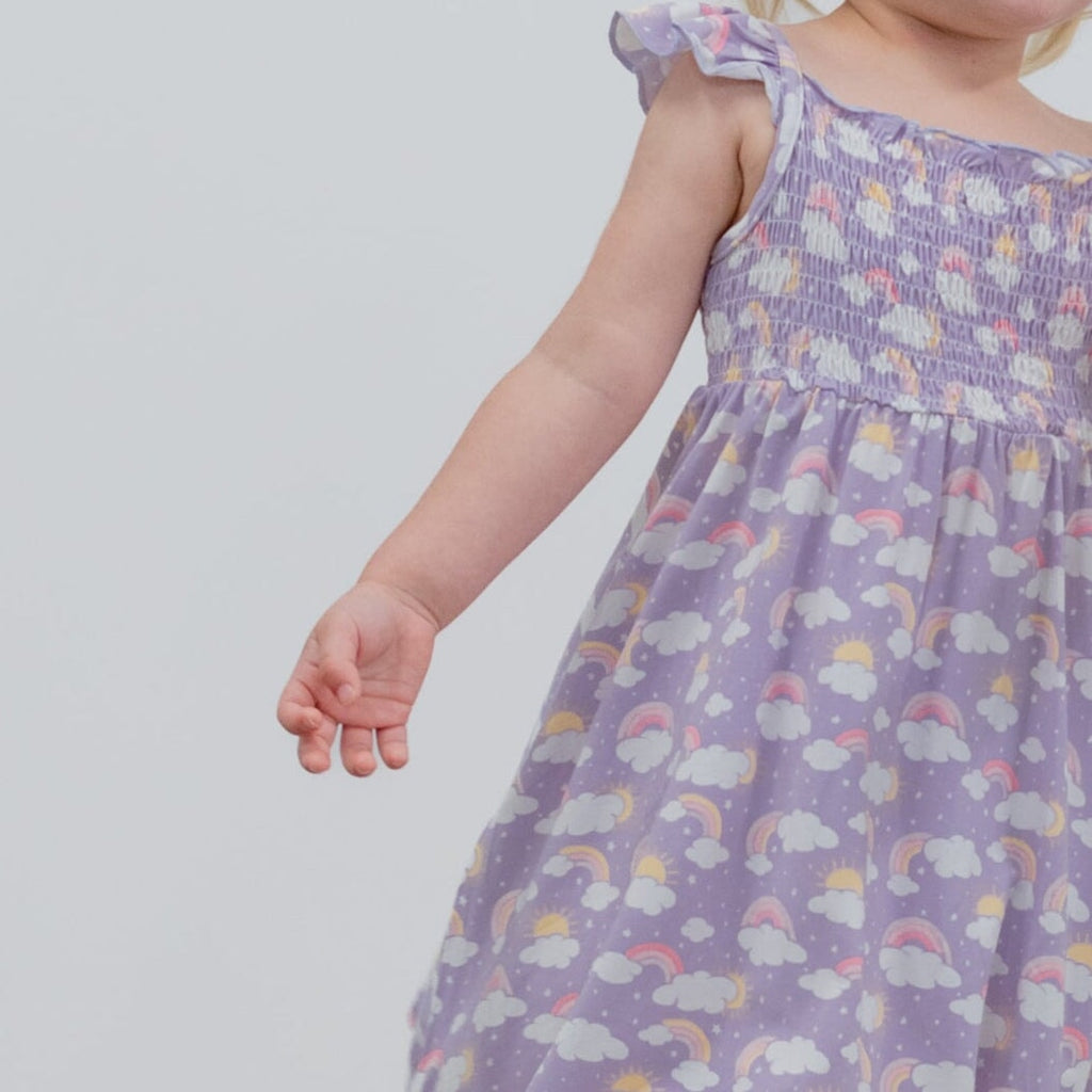 Girls lavender smocked sundress with rainbow and cloud print, gathered waist
