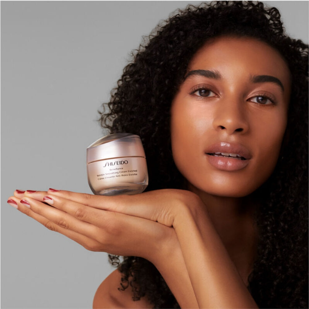 Shiseido Benefiance cream jar held in hand, pale cream visible