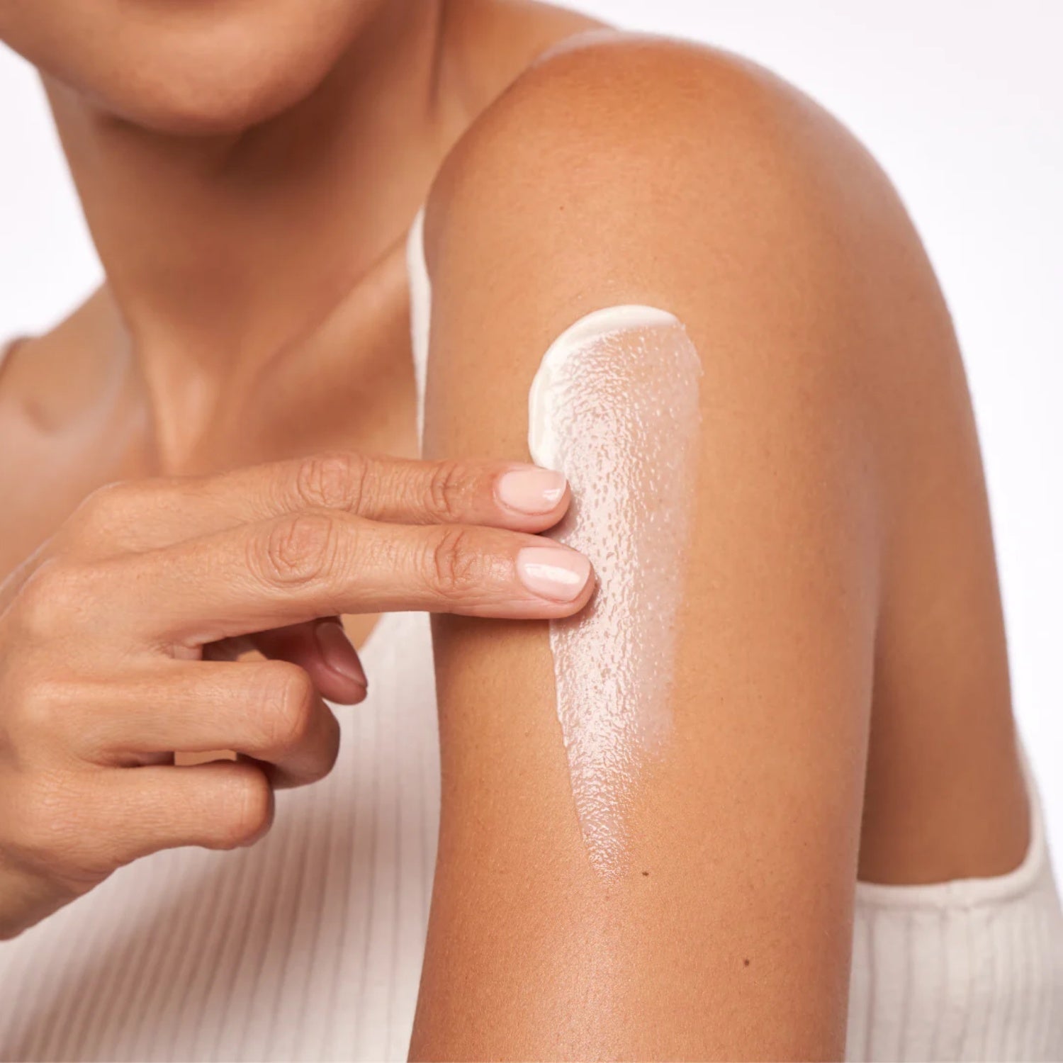 Alastin body treatment applied to shoulder, thick white cream texture