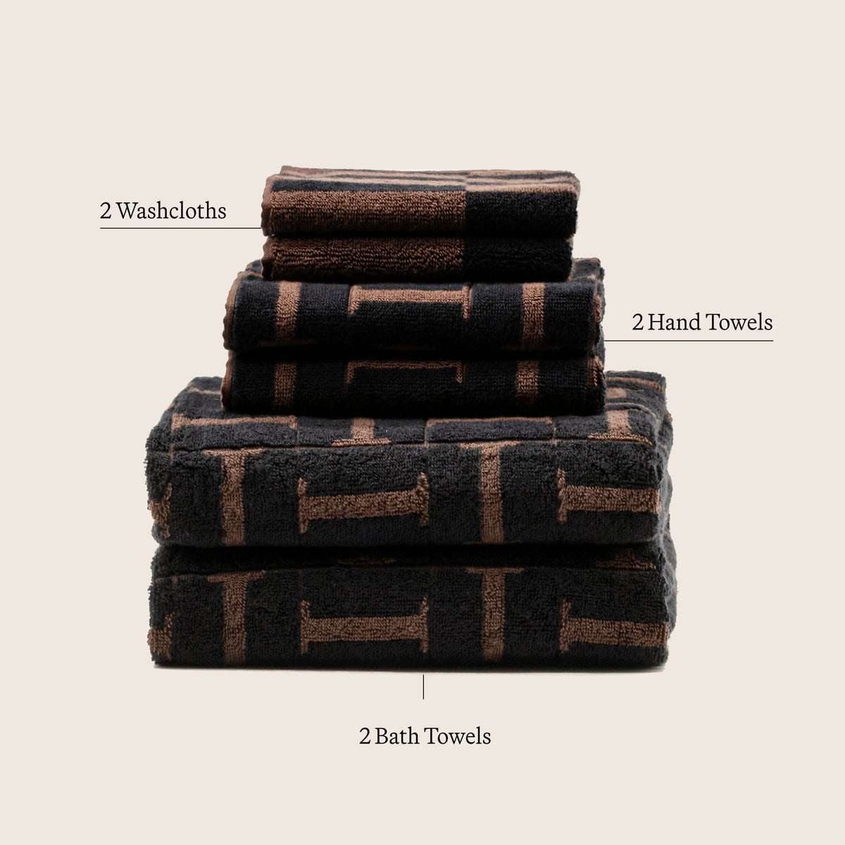 Neatly stacked folded cotton towels with tobacco brown and black geometric plaid blocks