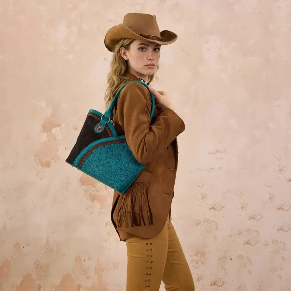 Turquoise tote bag with patterned front panel, carried over shoulder with dual straps.
