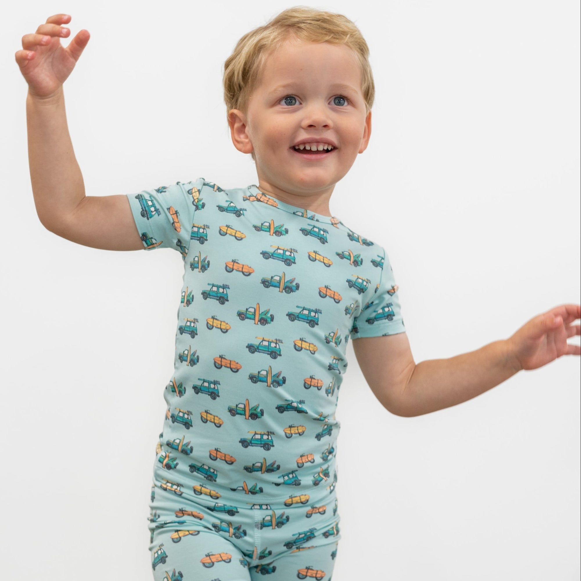 Boys light blue pajama set top with short sleeves and allover surf-and-vehicles print