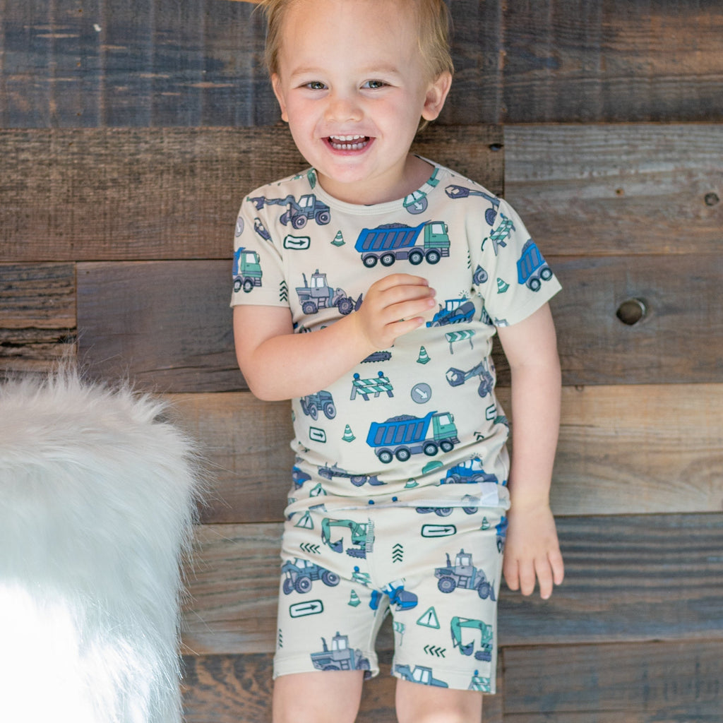 Kids' construction pajama set on boy, short-sleeve shirt and shorts with vehicle print