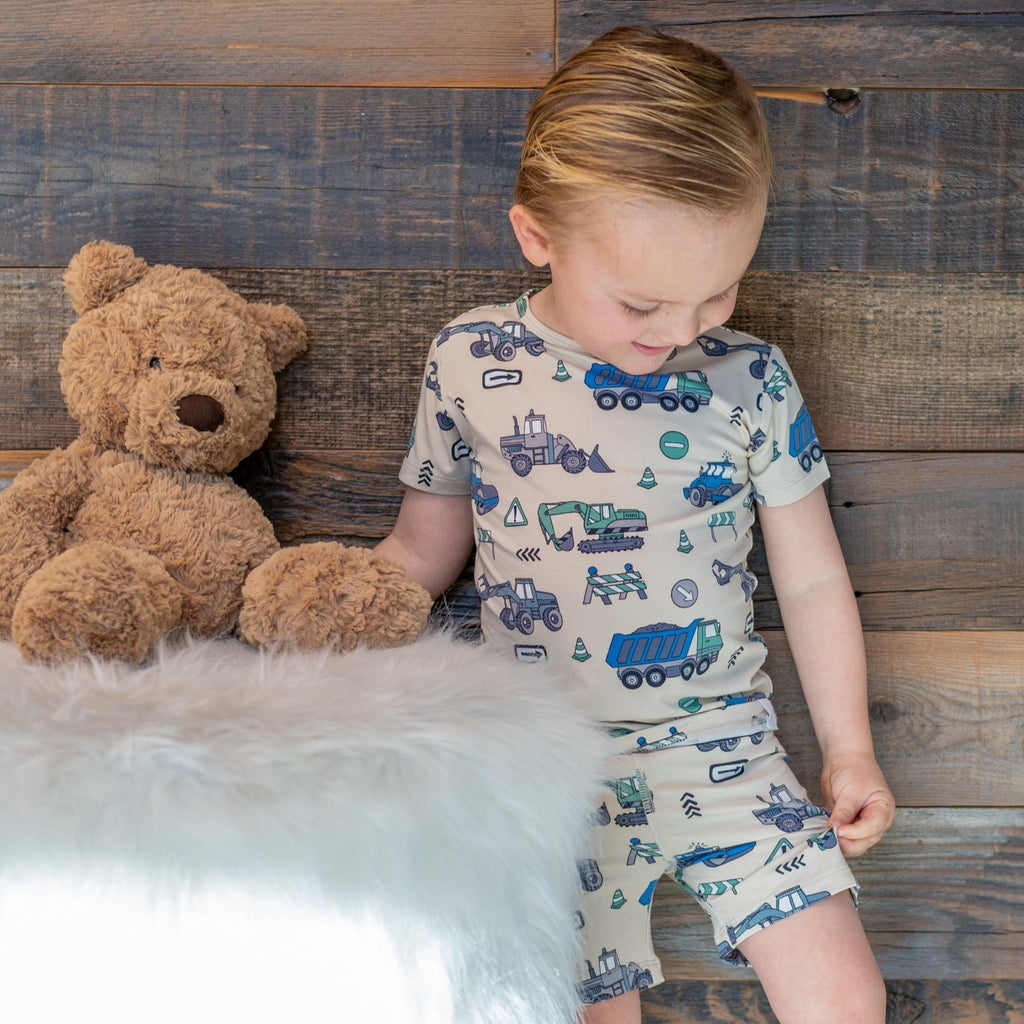 Kids' construction pajama set on boy, short sleeves and shorts with all-over vehicle print