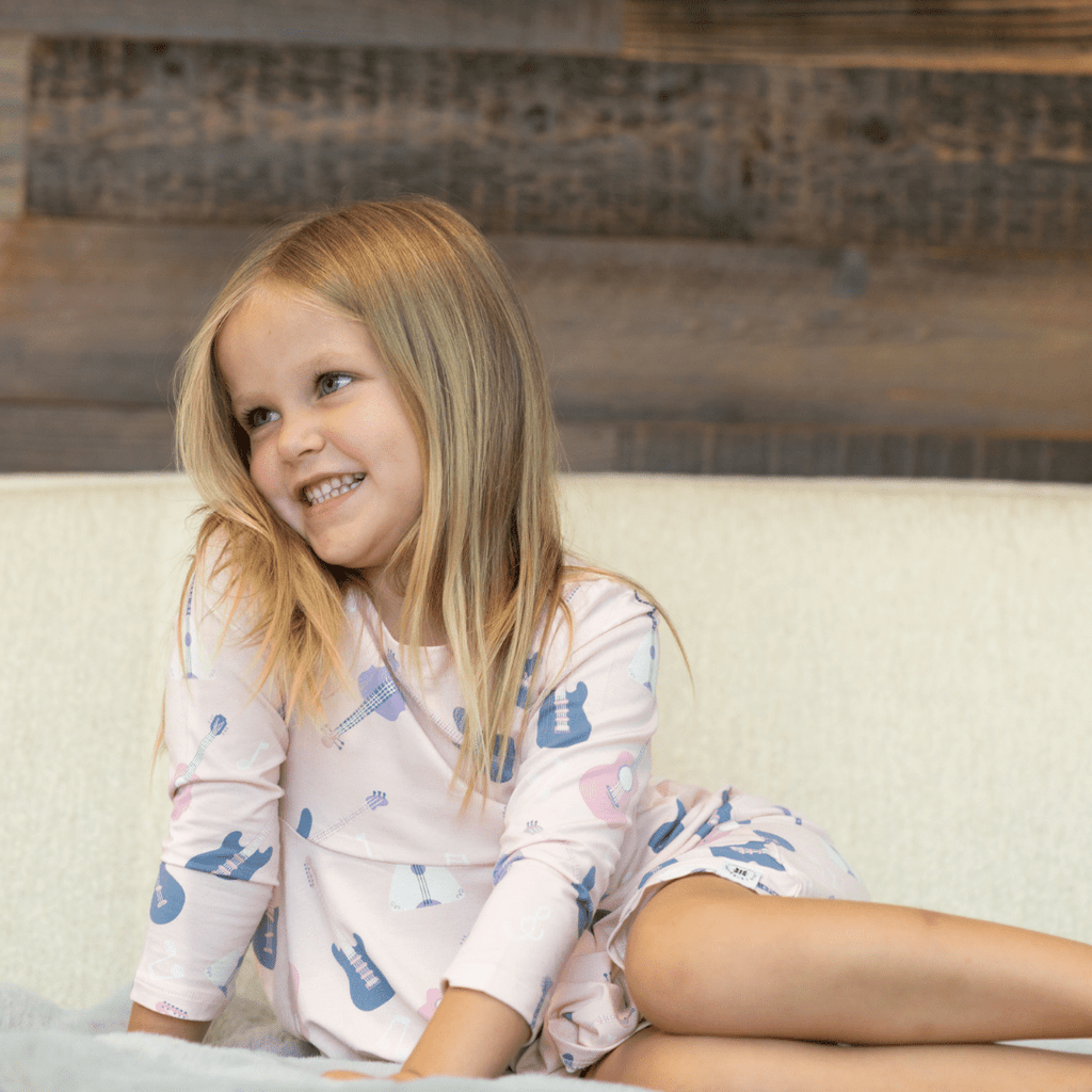 Girl's swirly dress in light pink with guitars and music icons, long sleeves