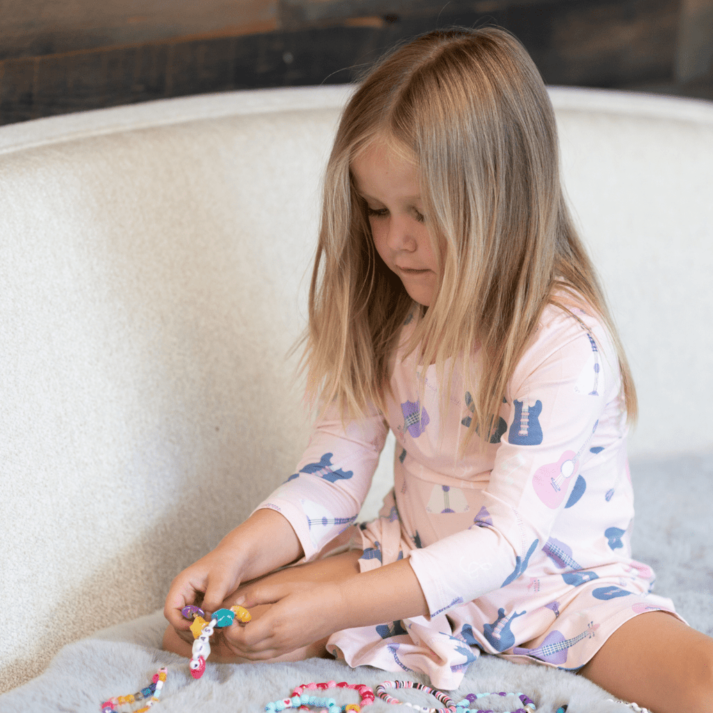 Girl's swirly dress in light pink with guitar/music note print, long sleeves