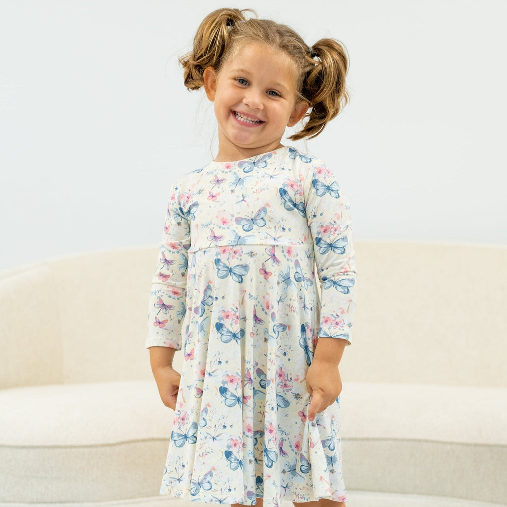 Girl's watercolor butterfly dress with long sleeves and gathered waist, light cream