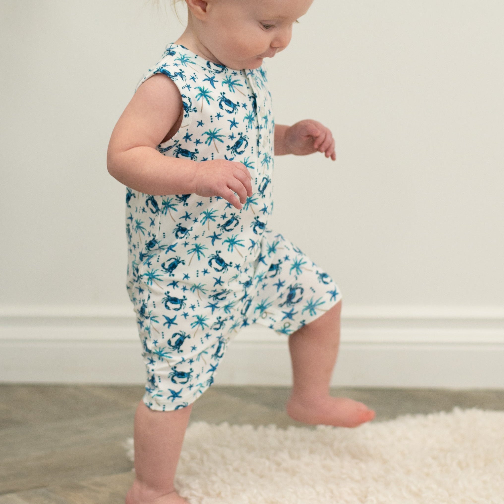 White blue crab and palm print tank romper on toddler, side view