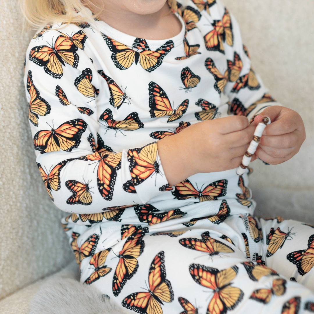 Kids pajama top, white long-sleeve with orange and black butterfly print
