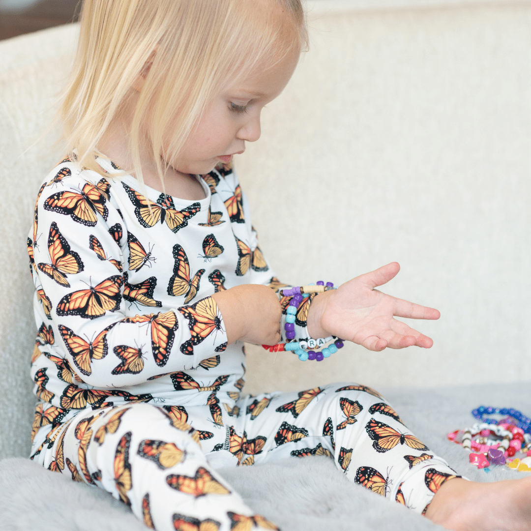 Kids pajama set, white long-sleeve with butterfly print, worn with matching pants