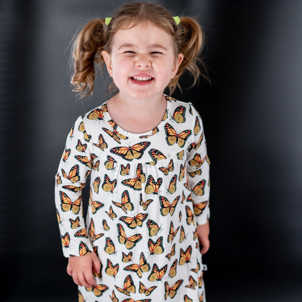 Kids butterfly print dress with white base, orange and black butterflies, round neckline