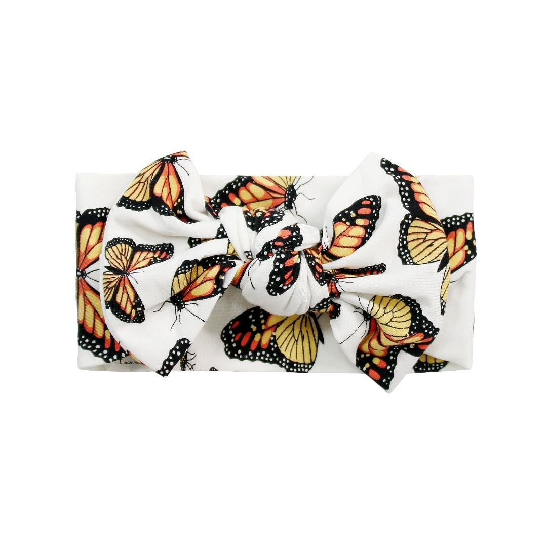 Knotted bow hair accessory with butterfly print on white fabric