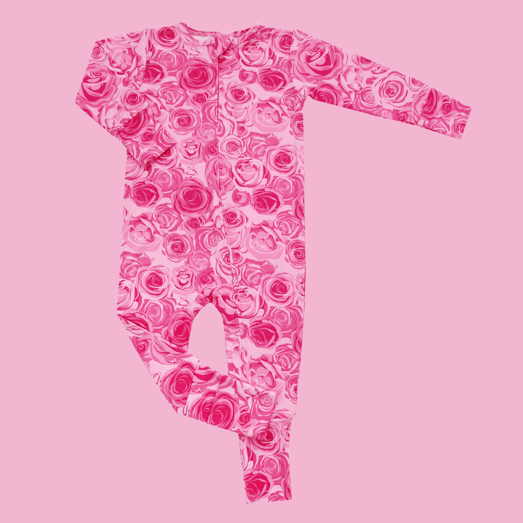 Girl's pink rose-print long-sleeve romper, flat lay, angled