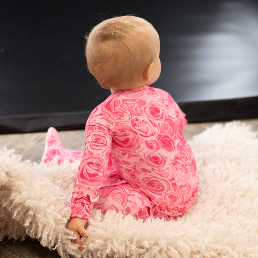 Pink rose-print ruffle footie viewed from back with long sleeves and feet