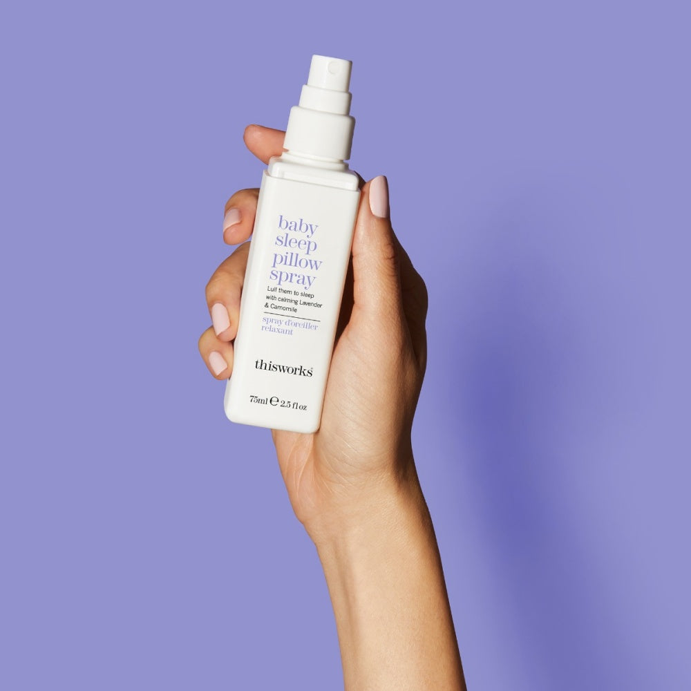 Baby sleep pillow spray bottle held in hand with white spray cap