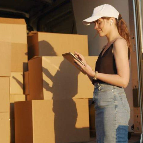 Reshipping fee service: person carrying a stack of boxes and a clipboard.