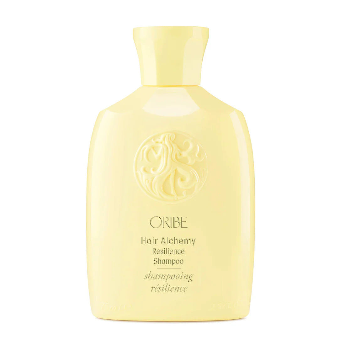 Pale yellow Oribe shampoo bottle with crest logo and centered Hair Alchemy label