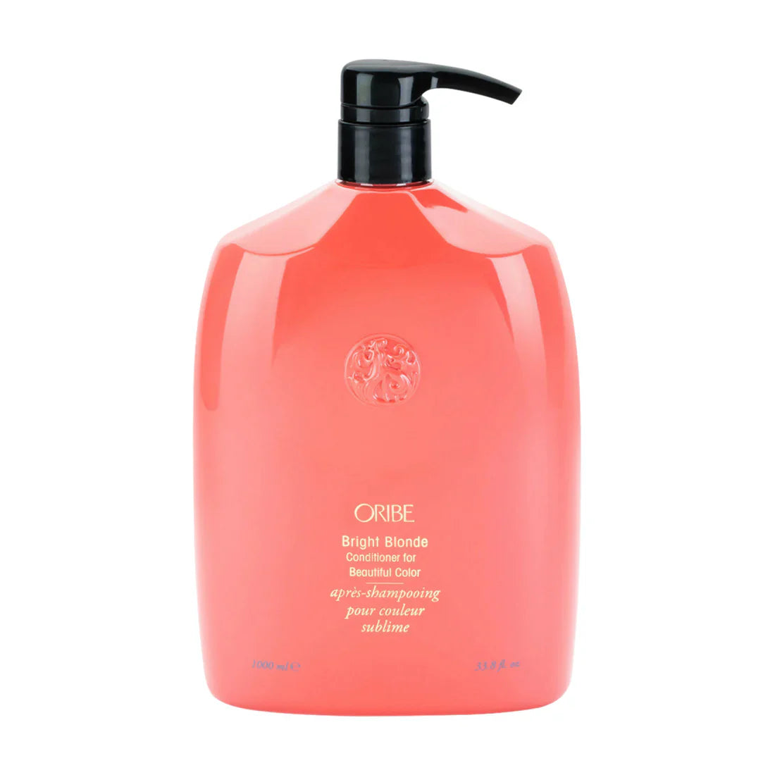 Oribe conditioner bottle, coral pink with black pump and circular emblem on front