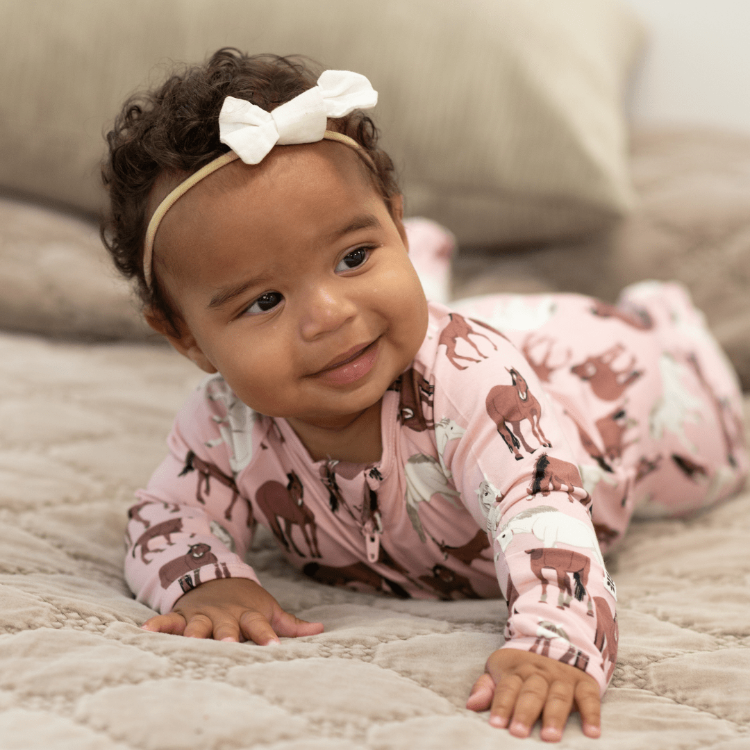 Girl zip-front horse-print footie in dusty pink, long sleeves and covered feet