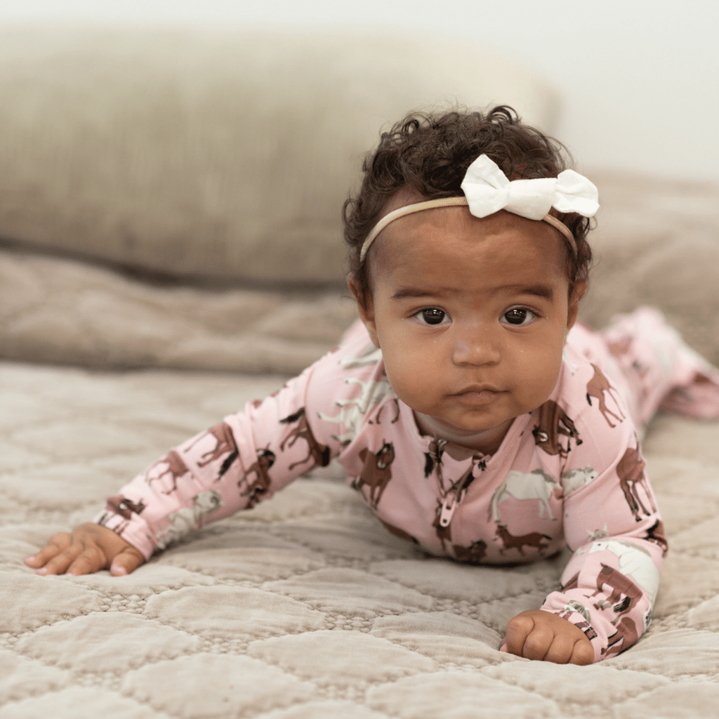 Girl zip-front horse-print footie in dusty pink, long sleeves and covered feet