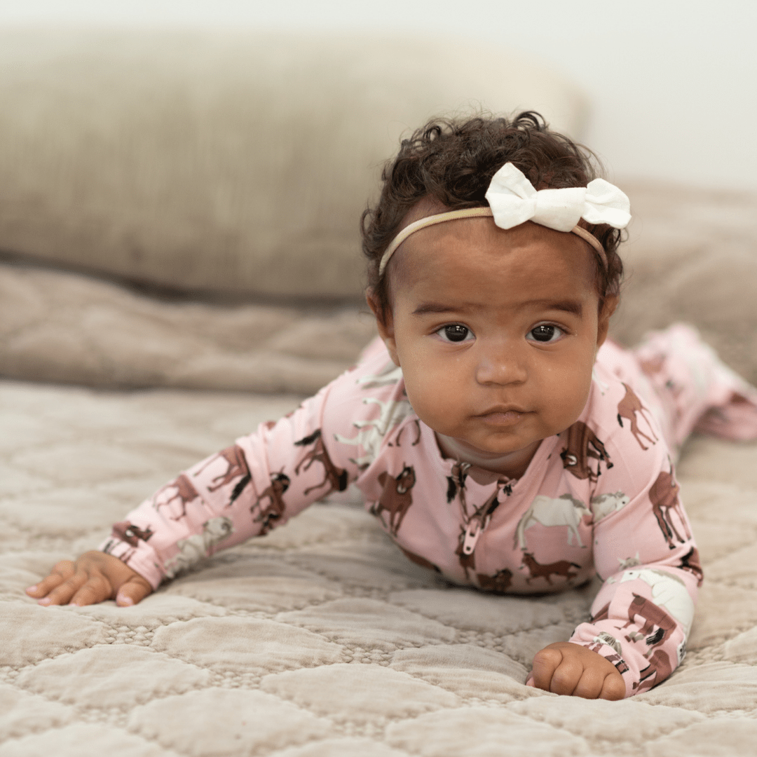 Girl zip-front horse-print footie in dusty pink, long sleeves and covered feet