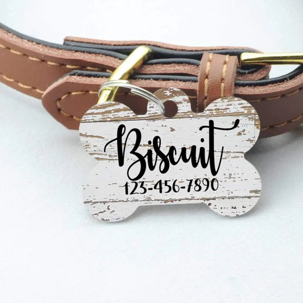 Wood grain pet ID bone tag on brown leather collar, with engraved name and phone number