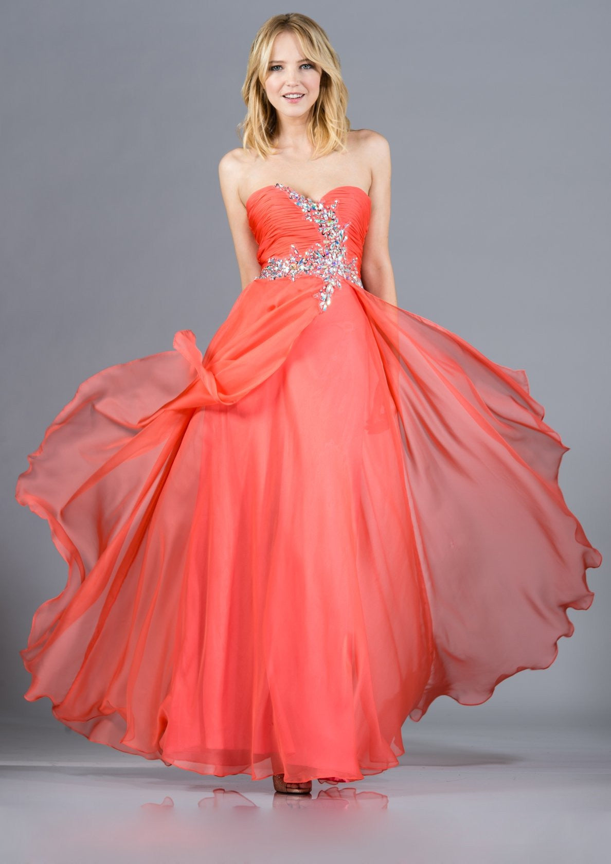Strapless coral prom gown with beaded bust applique and voluminous layered chiffon skirt