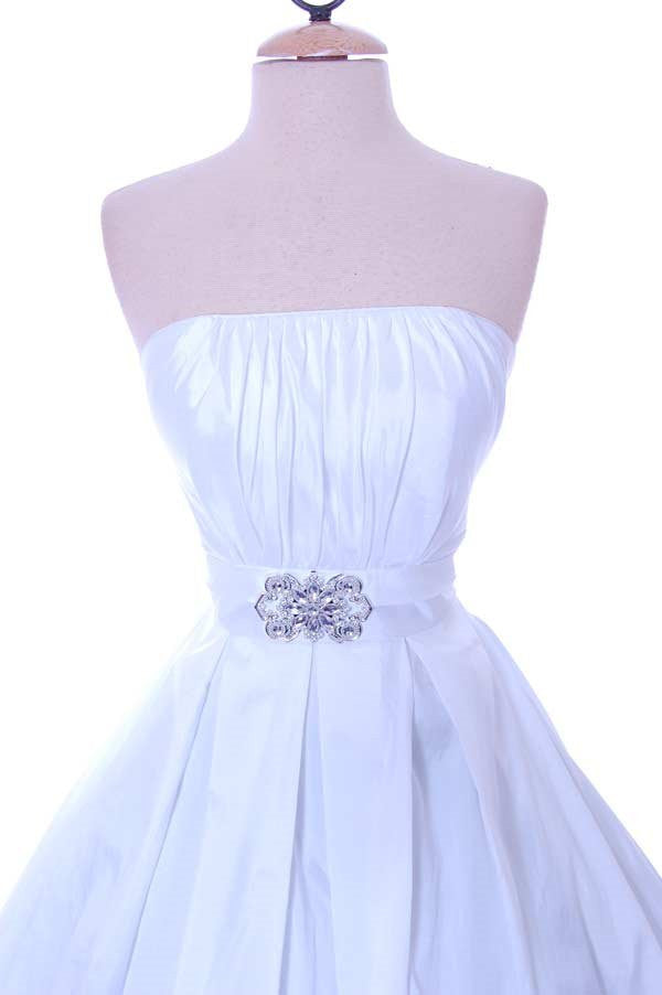 White strapless A-line dress with ruched bodice, floral waist applique, and full tulle skirt