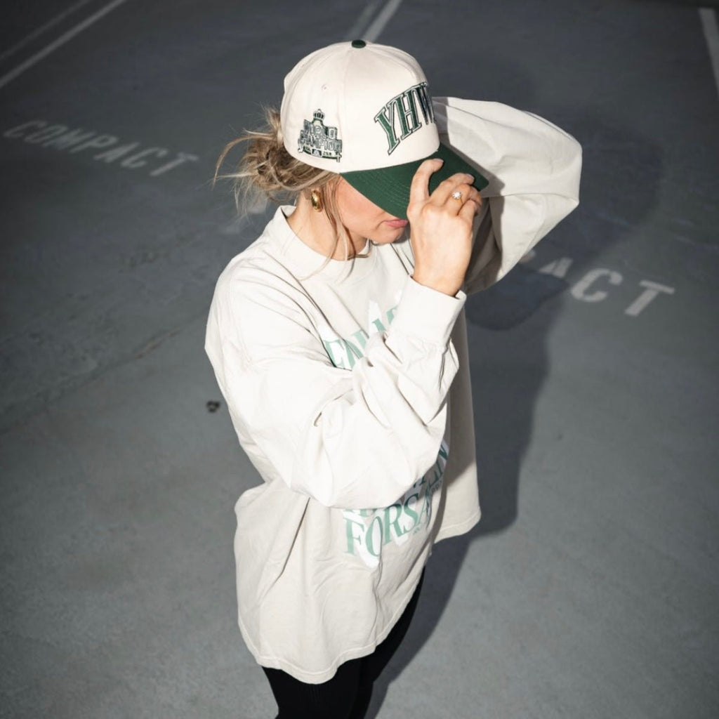 Cream and dark green snapback cap worn with YHWH front logo