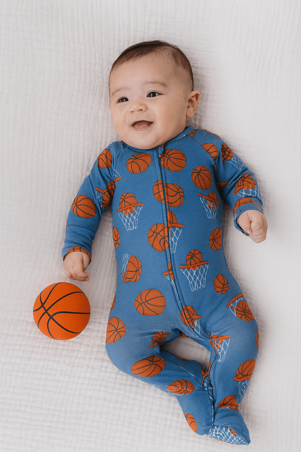 Blue basketball-print zip-up footie with orange ball graphics and long sleeves