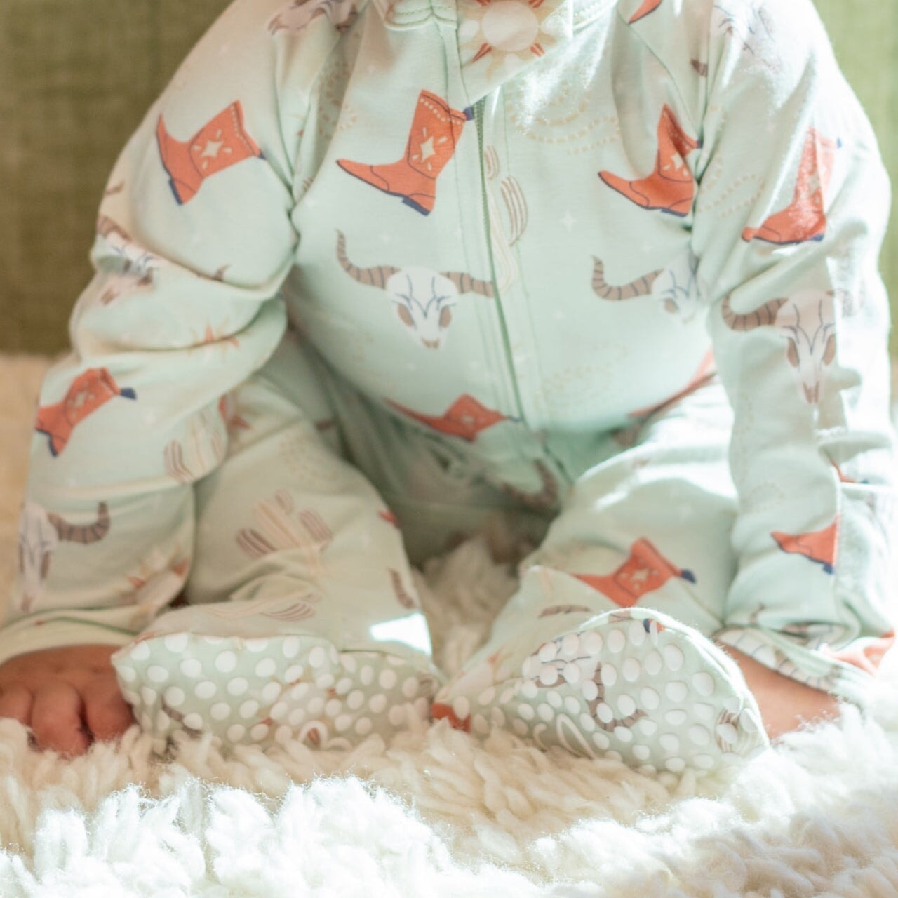 Light blue baby footie romper with cowboy boot and cactus print, zip front