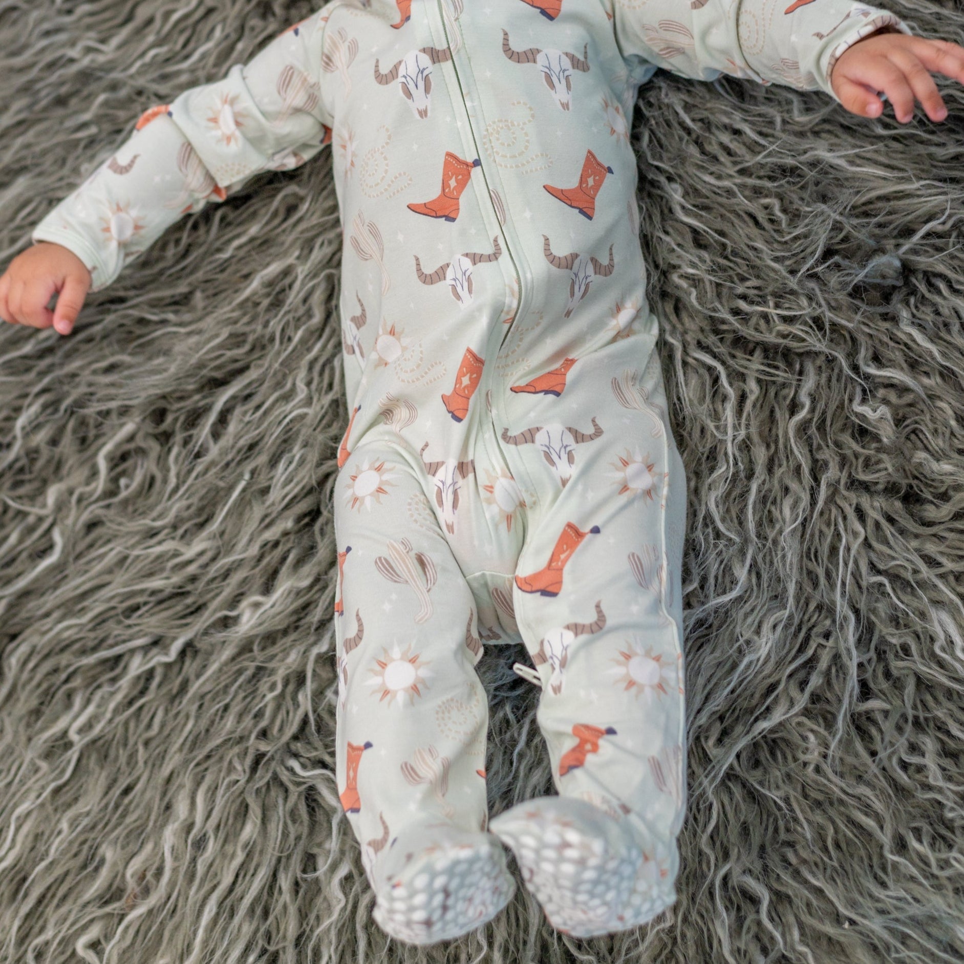 Light blue baby footie romper with cowboy boot and cactus print, footed cuffs