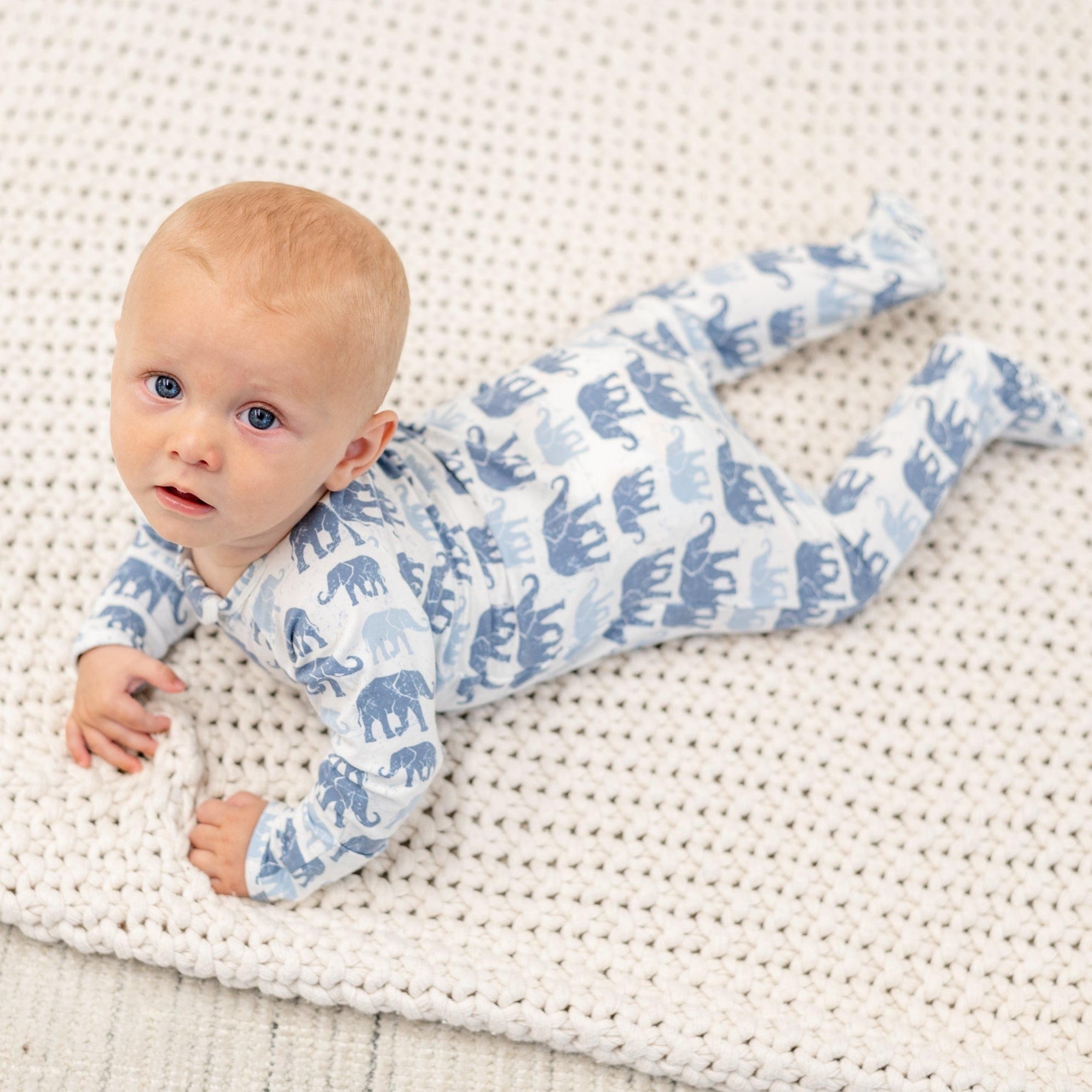 Infant light-blue elephant print zipper footie, front view with footed legs
