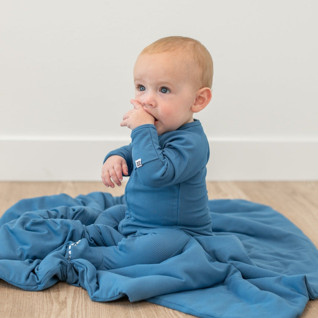 Blue zip-up footie pajama on baby, long sleeves and front zipper